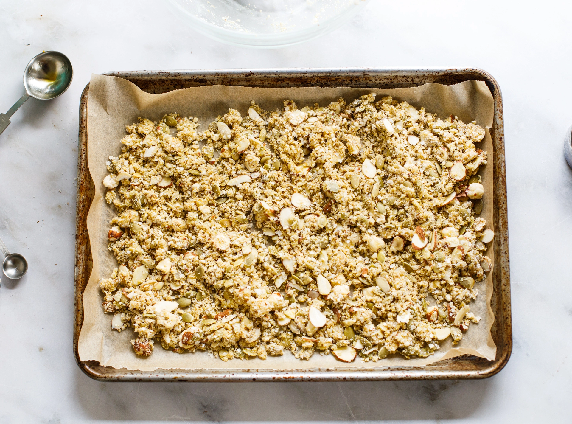 Quinoa granola ingredients on baking sheet ready to bake