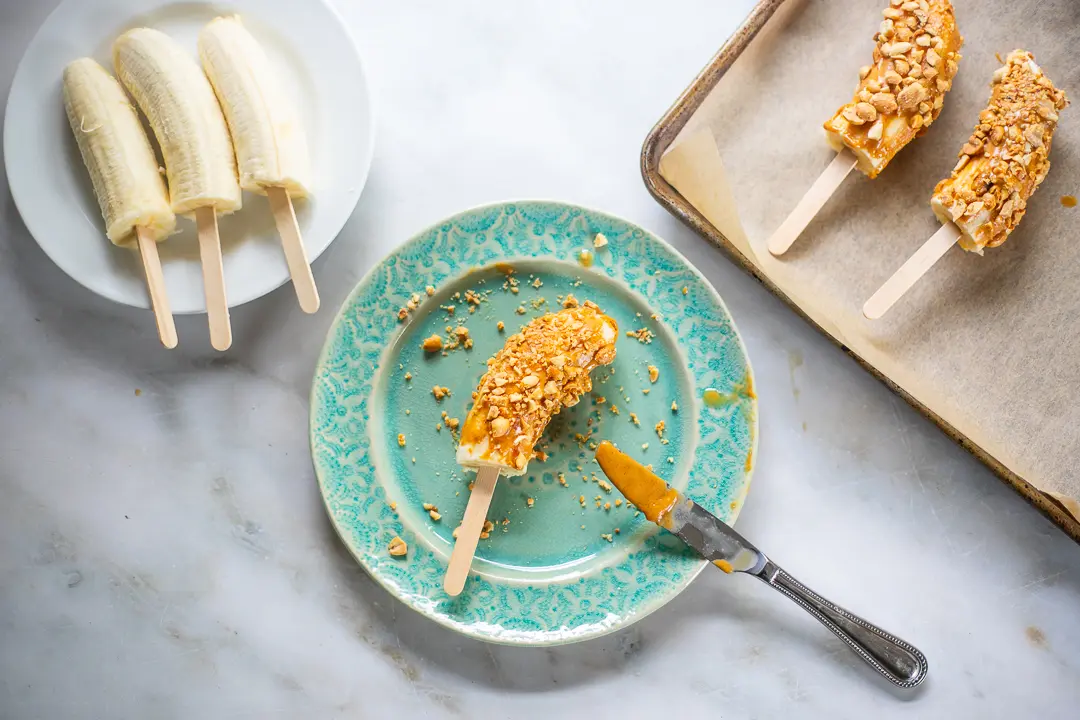 Frozen Dipped Banana Pops covered in peanut butter and peanuts