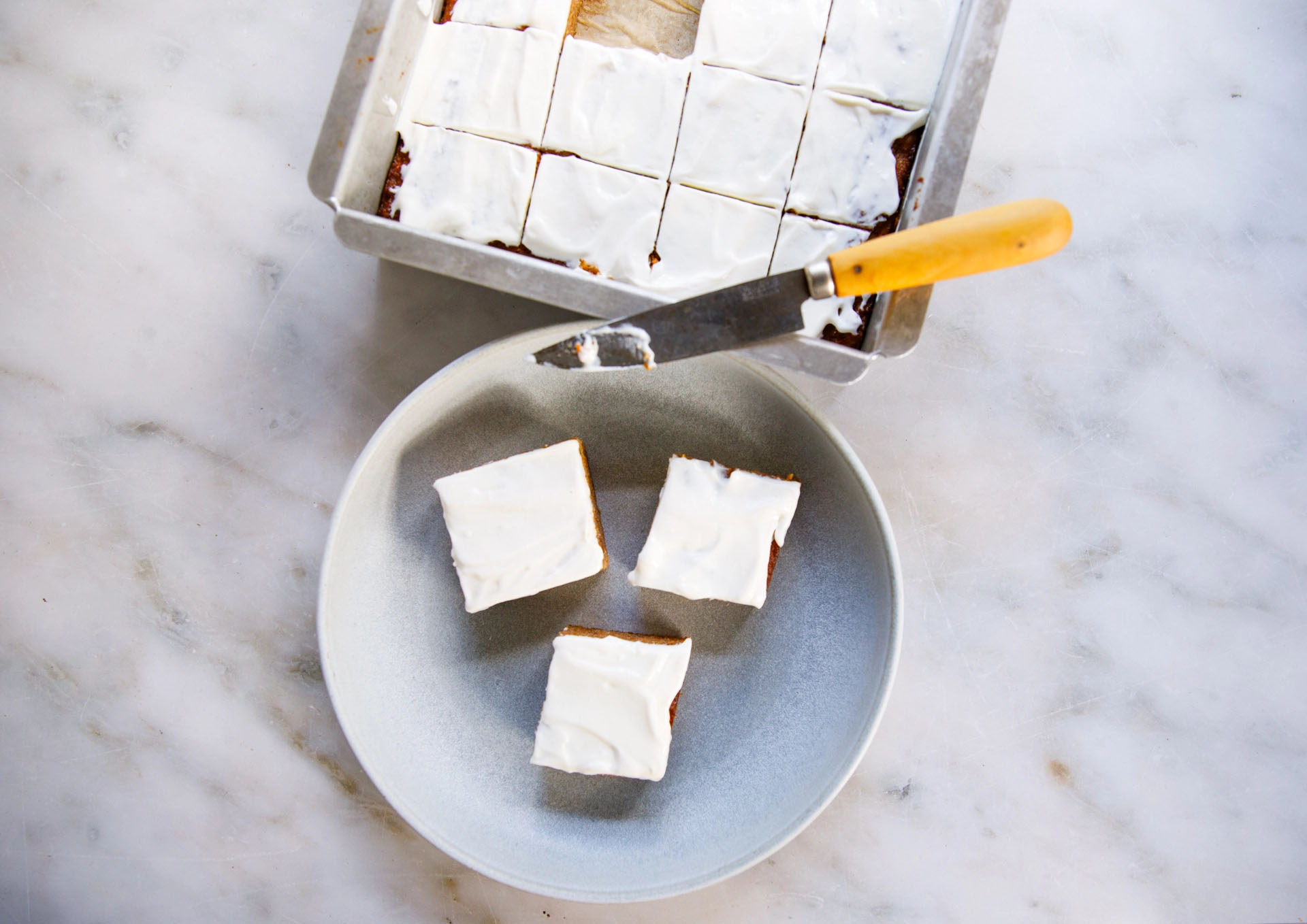 Carrot snack cake frosted and sliced overhead view