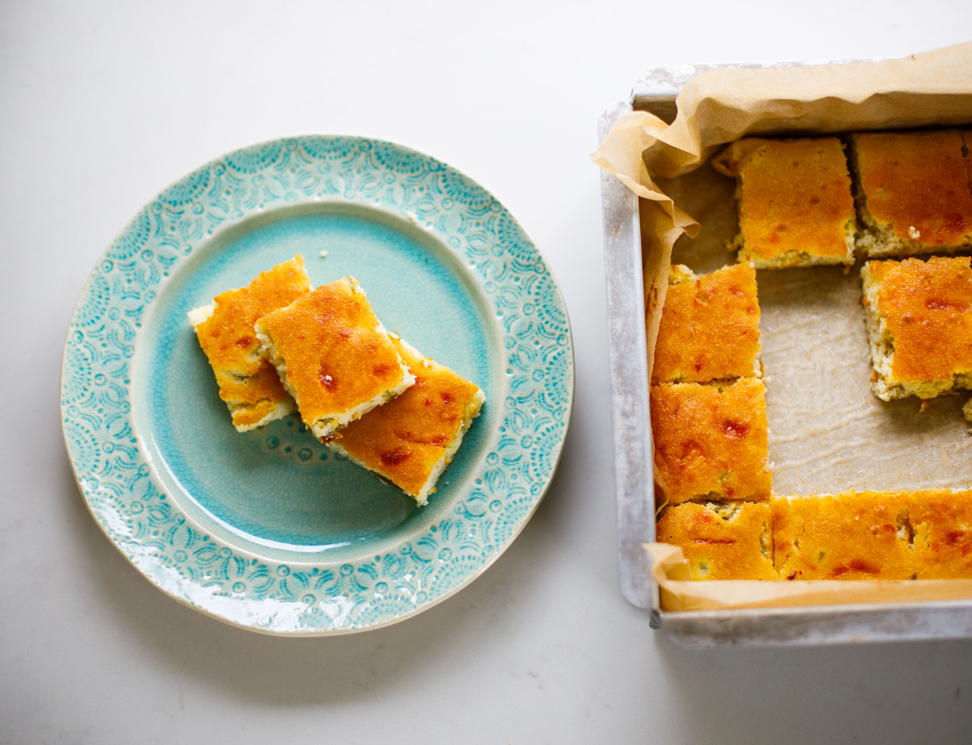 Jalapeno Cheddar Corn Bread sliced into squares in pan