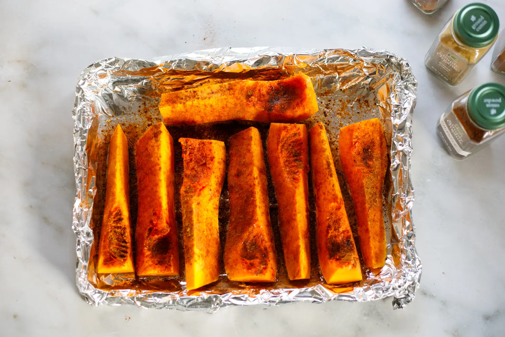 Sliced butternut squash rubbed with oil and spices