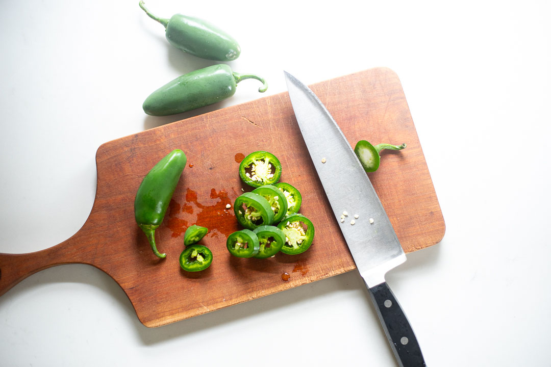 Jalapeños sliced on cutting board