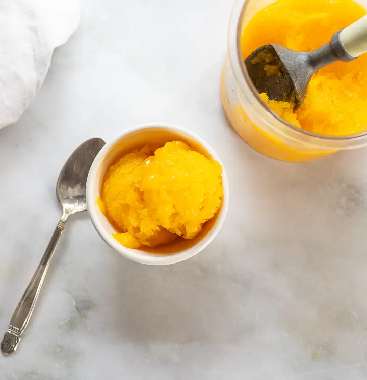 Overhead view of mango sorbet serving and container
