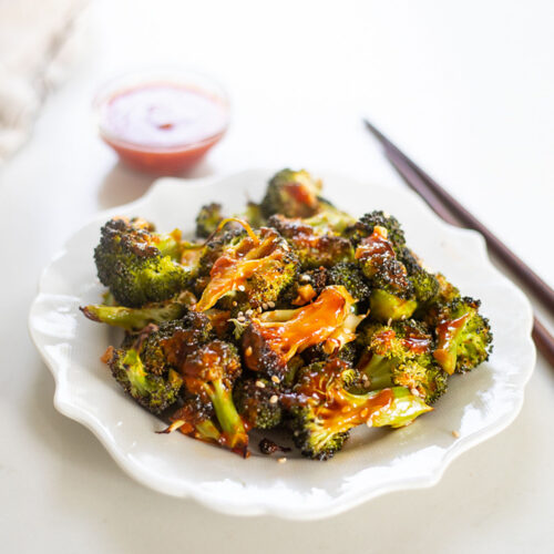 Orange Sesame Broccoli on plate with sauce and chopsticks